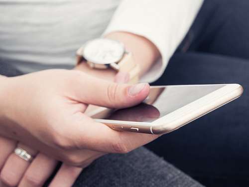 Sitting girl in a white blouse uses the phone