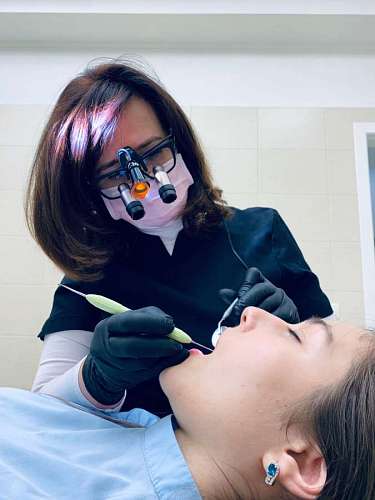 dental female dentist checking her patient's mouth