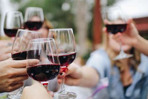 Groups of people toasting with glasses of wine at a celebration