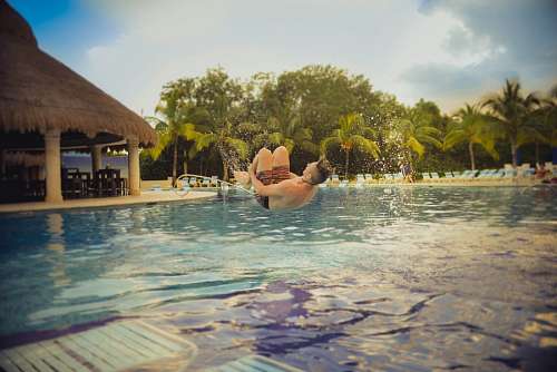A young boy Jumps to the swimming pool