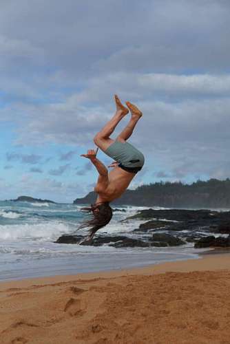 Man jumping back on the beach