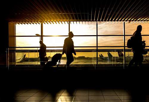 airport-terminal Silhouettes of people walking in an airport at sunset