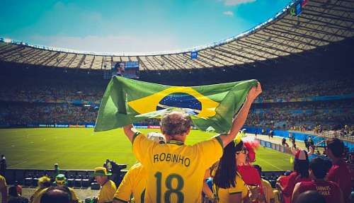 raised A fan raise a Brazilian flag in a soccer game