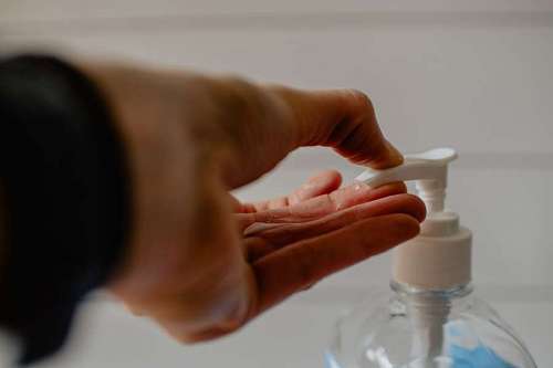 woman spreading gel alcohol on her hand