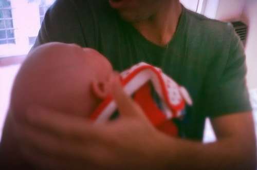 Father carrying his newborn in his arms