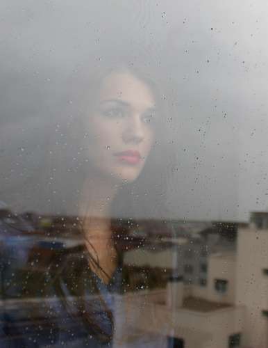 melancholy Woman looking through a window
