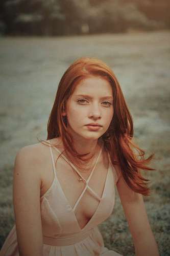 conceptual-symbol Young redhead woman in dress looking at camera