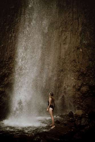 woman standing in front of beautiful waterfall
