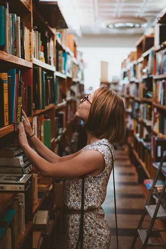 shelf woman looking at books in a library