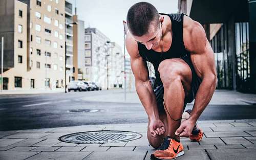 alexa fitness man tying shoelaces on the street