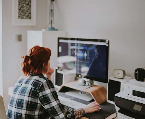 red-haired woman uses her computer