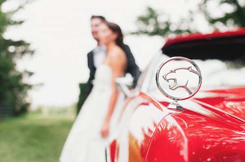 luxury Jaguar with couple in the background