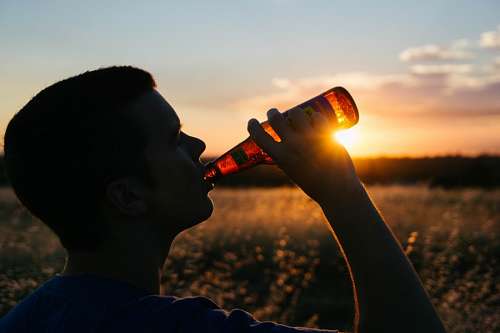 please Man drinking a beer at sunset