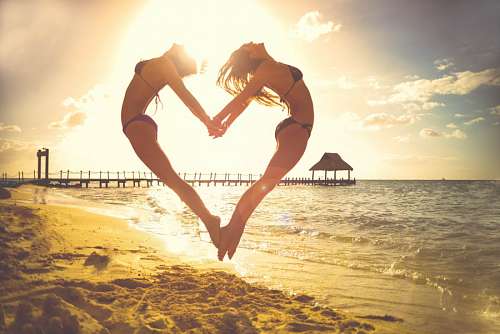 Girlfriends on the beach jumping