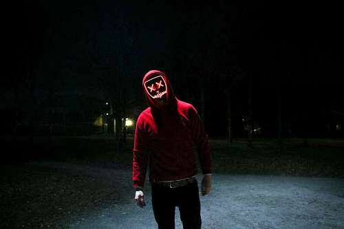 Man wearing halloween mask at night