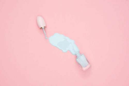 conceptual-symbol Spilled White Nail Polish on Pink Surface