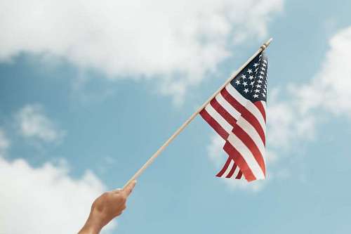 weave Hand holding usa flag against blue sky