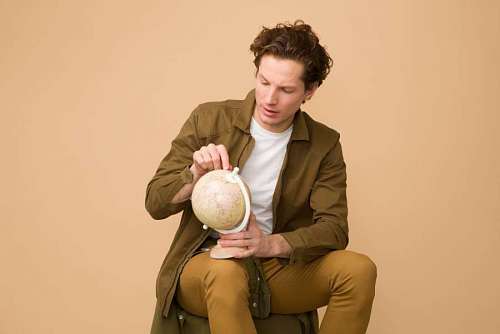 location Young man with earth globe looking for place for a new trip