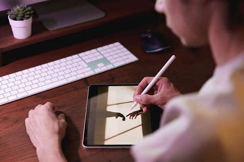 job Designer retouching a digital image with tablet from home