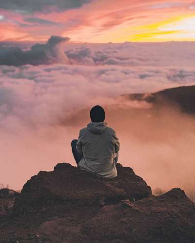 Man meditating on top of a mountain