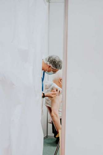 looking-over-shoulder Applying vaccine against covid 19