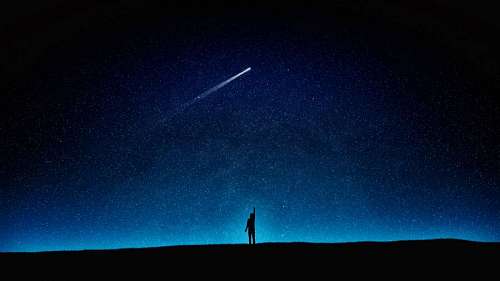 comet silhouette of a boy look at a kite in the starry sky
