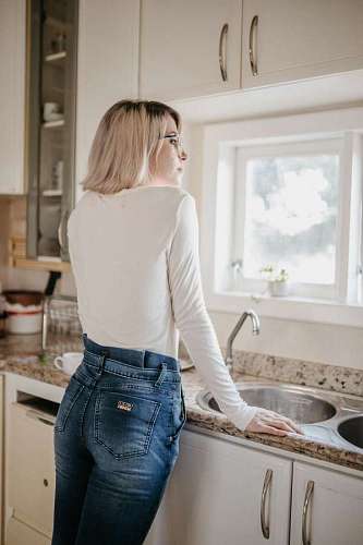 businesswoman Young woman looking out the window in the kitchen