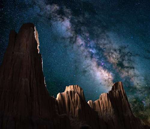 hiker Milky way between rocky mountains