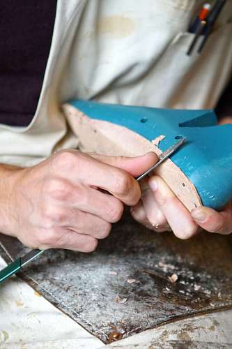 mold shoemaker trimming the sole with a shoe mold