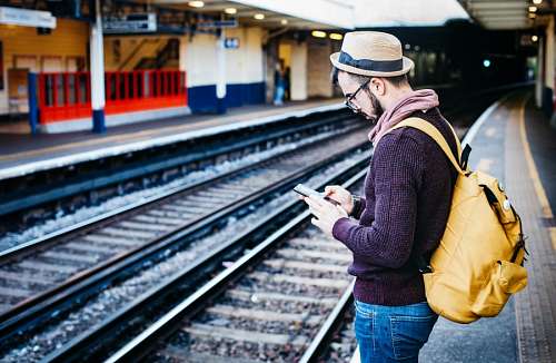 send-packages-made Traveler texting at train station
