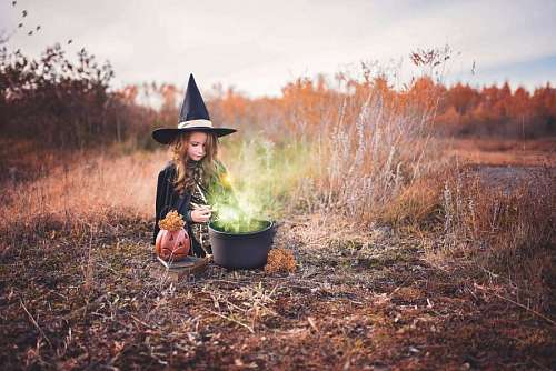 preparing-to-work Girl dressed as a witch preparing a magic potion