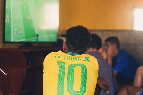 tv-camera Man wearing soccer brazilian tshirt watching tv