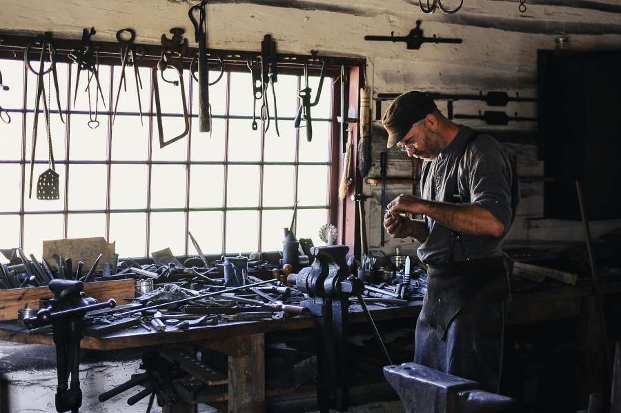 a person, man, workshop, interior, work, tool, tools, adult, craftsman, blacksmith, press, barn, workplace, activity,