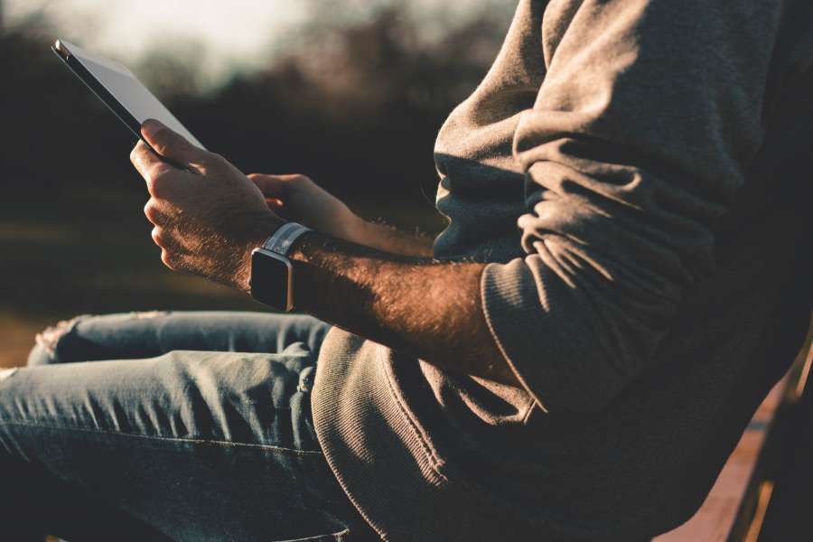 one person, man, young, adult, outside, sitting, park, plaza, tablet, technology, connectivity, app, day, electronic device, email,