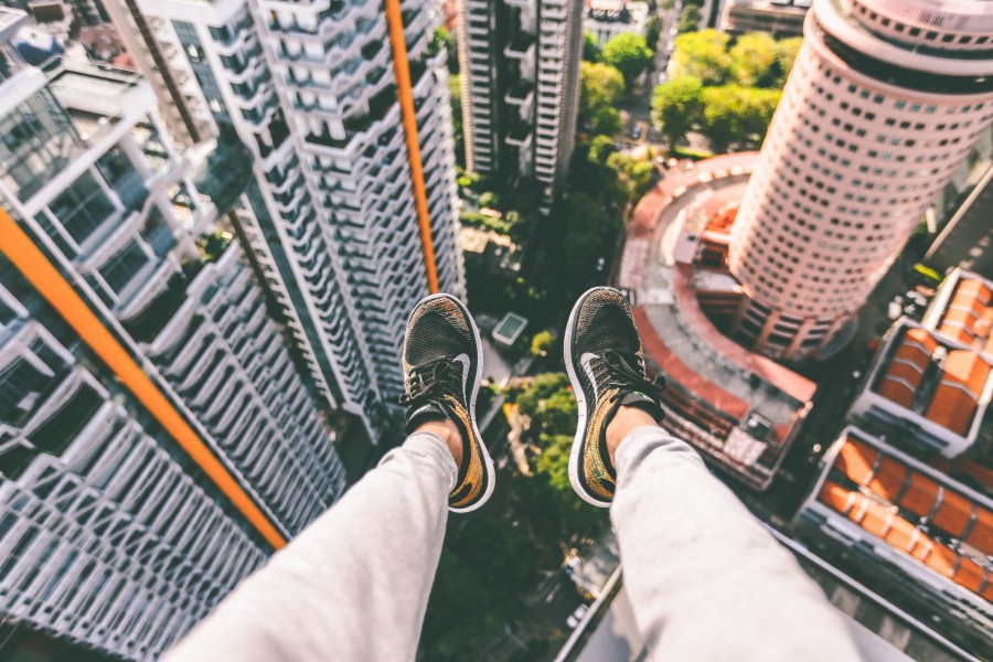 one person, people, man, shoe, shoes, boldness, daring, danger, edge, cornice, adventure, excitement, adrenaline, city, urban, top, sitting, 