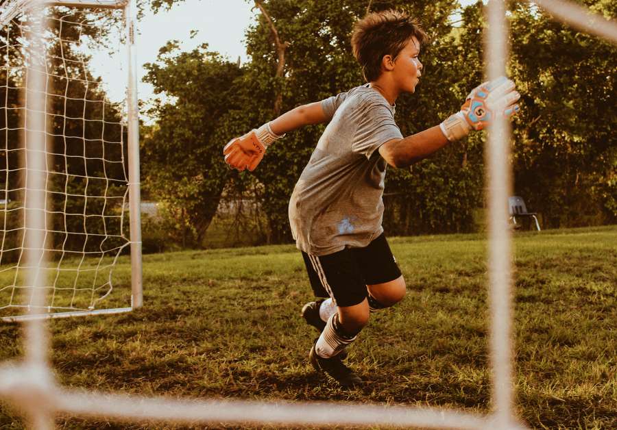 one person, child, game, sport, soccer, goal, net, goalkeeper, goalkeeper, goalkeeper, action, movement, 10 years old, activity,